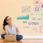 woman sitting on the floor in front of her computer with data above her head